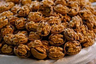 Fresh walnuts with shells cracked open, showcasing their creamy texture.