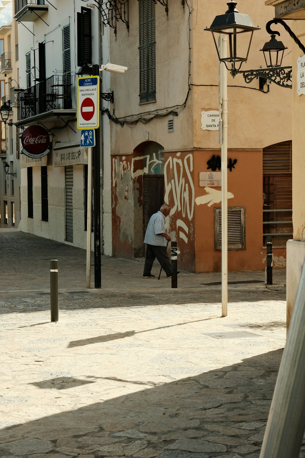 a man walking down a street next to a tall building