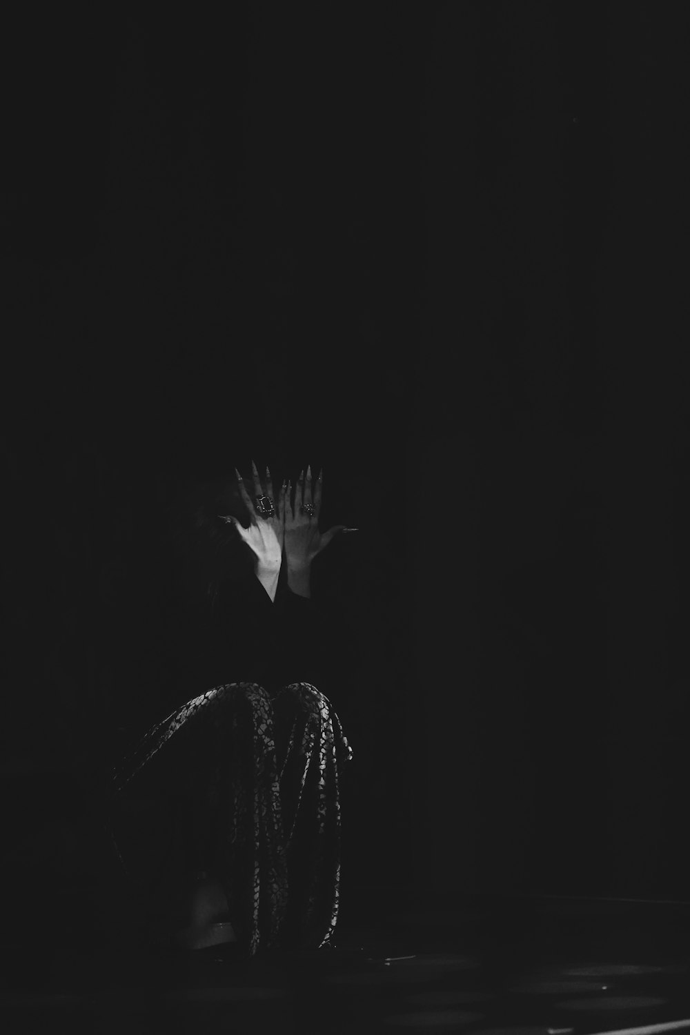 uma foto em preto e branco de uma flor no escuro