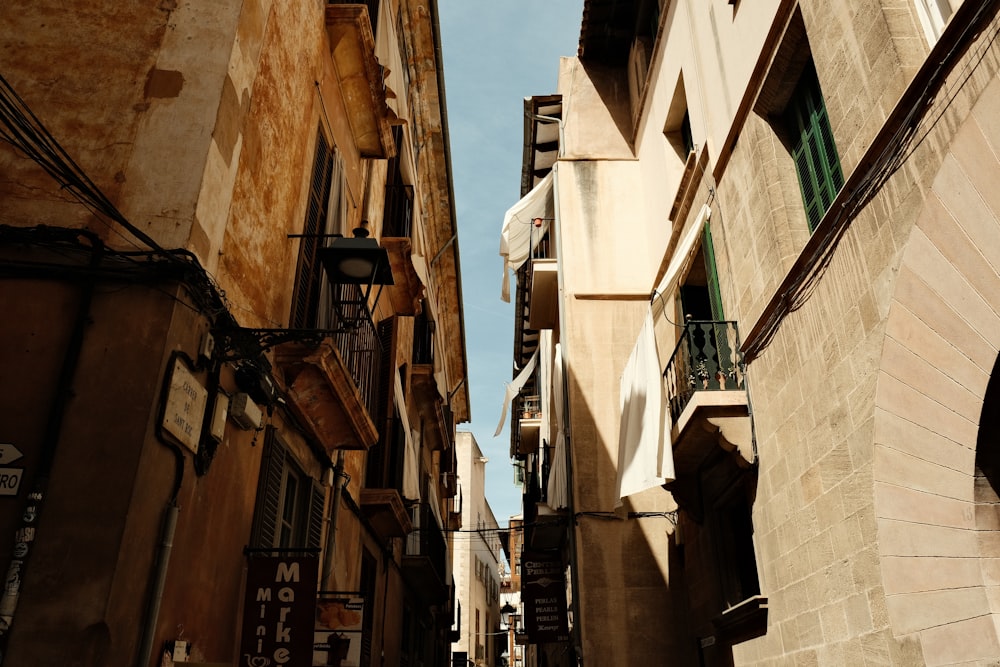 a narrow city street with buildings and a clock