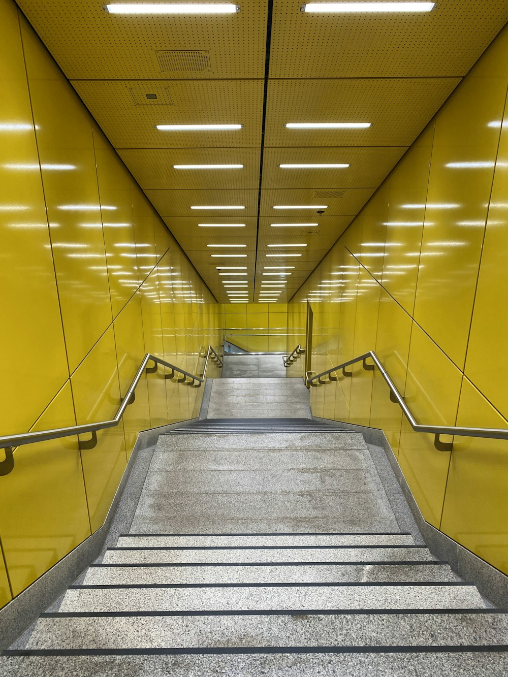 a long hallway with yellow walls and stairs