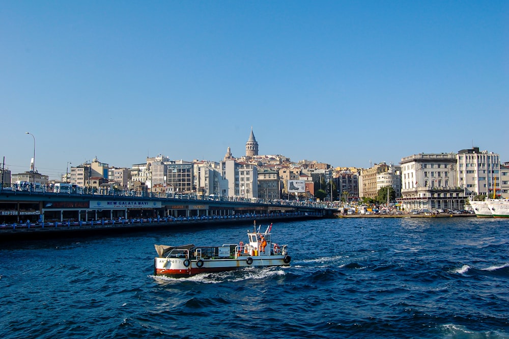 a boat traveling down a river next to a city