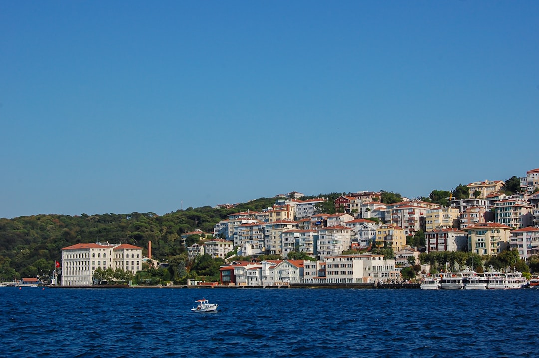 a boat in the water near a city on a hill,