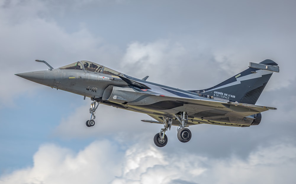 a fighter jet flying through a cloudy sky