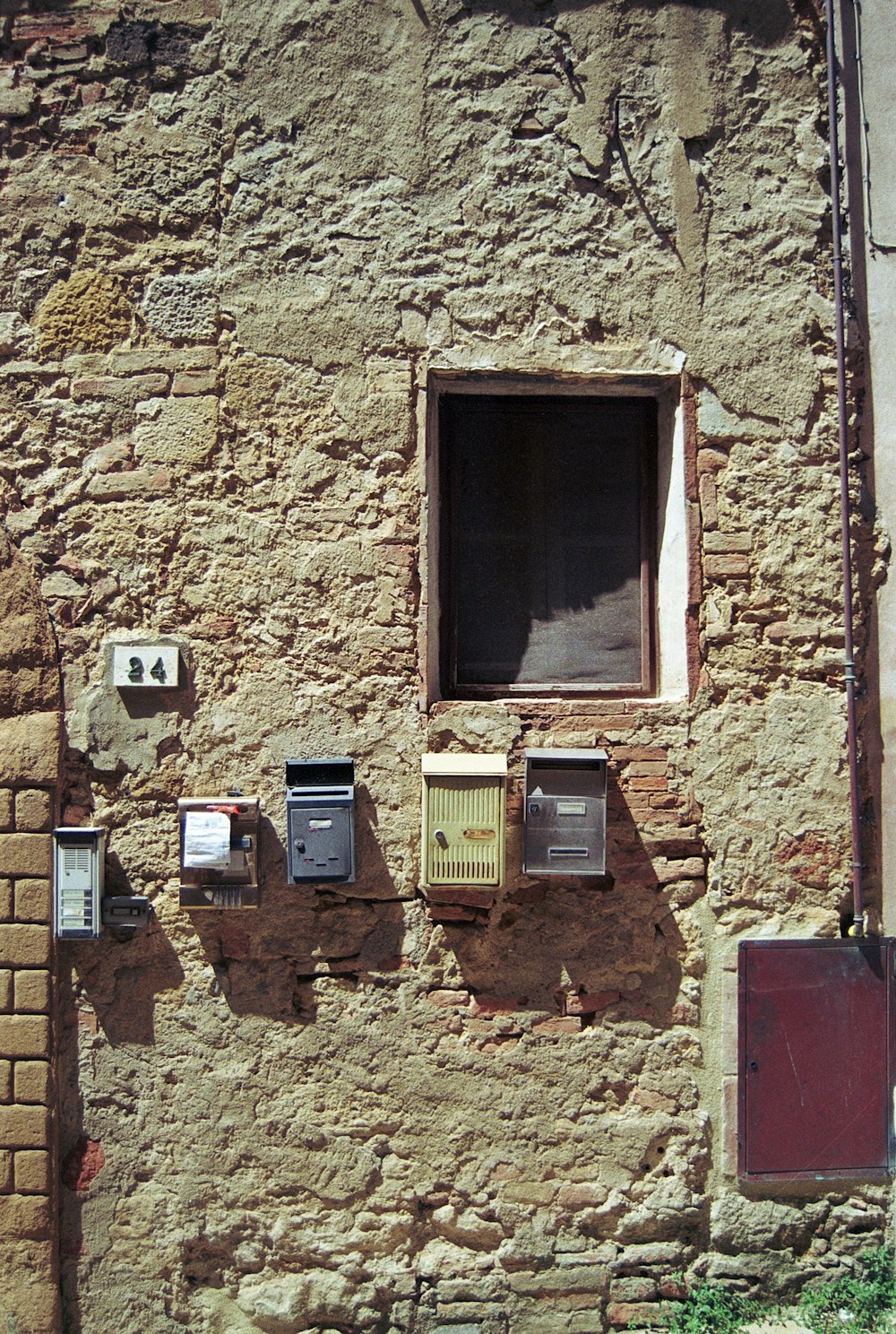 Un edificio in mattoni con una finestra e un mucchio di microonde su di esso