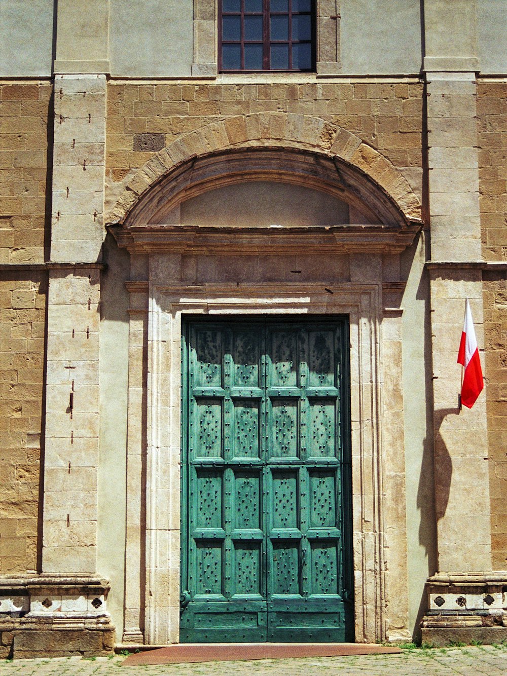 an old building with a green door and a canadian flag