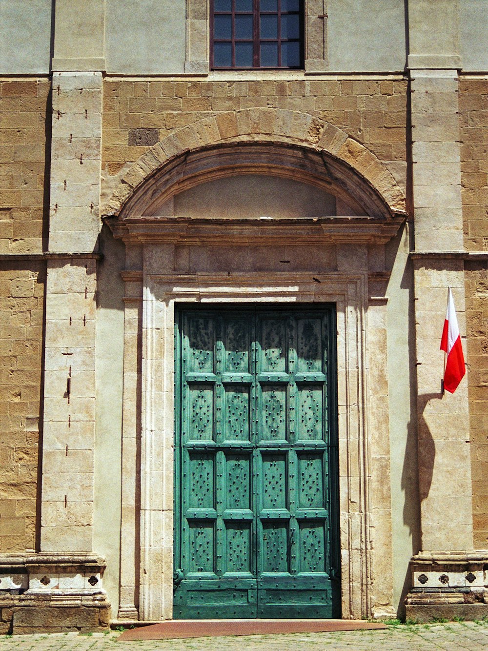 Un vecchio edificio con una porta verde e una bandiera canadese