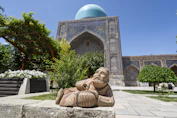 a statue of a man sitting in front of a building