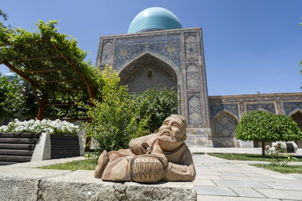 A statue of a man sitting in front of a building — Samarkand, Uzbekistan