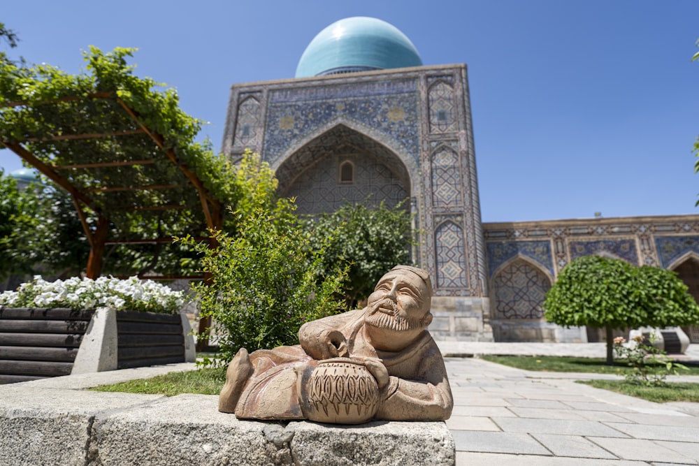 a statue of a man sitting in front of a building