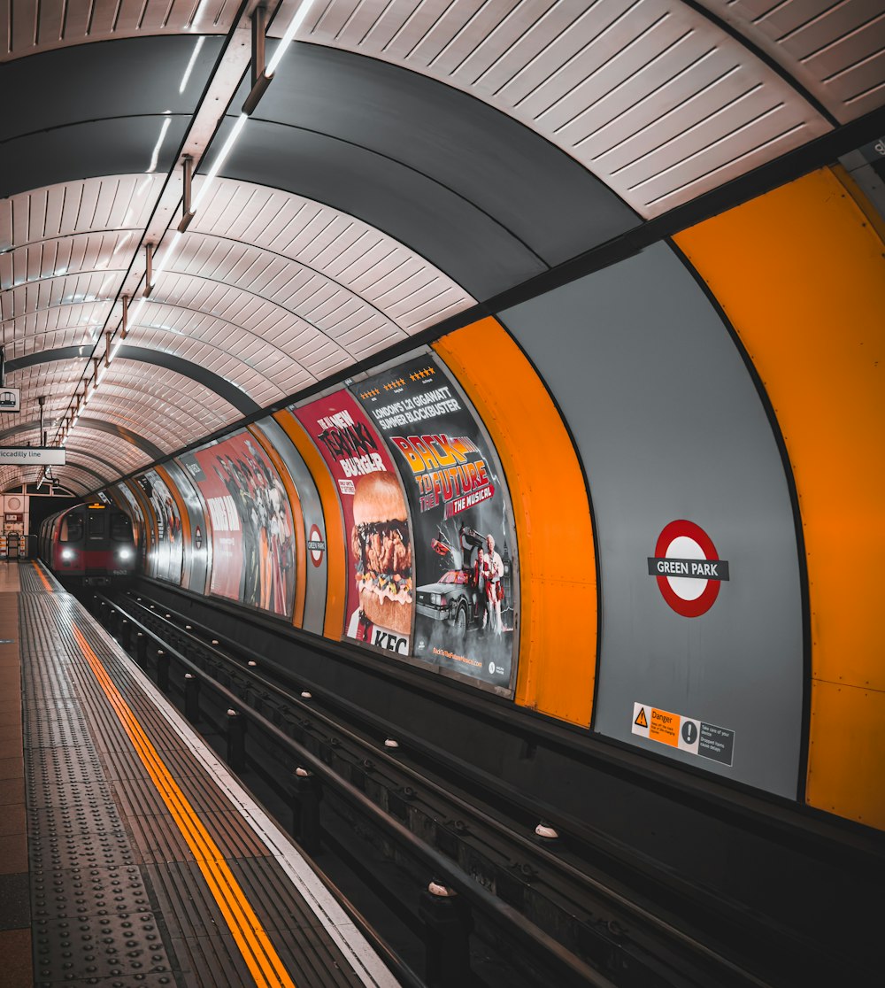 an orange and grey train pulling into a train station