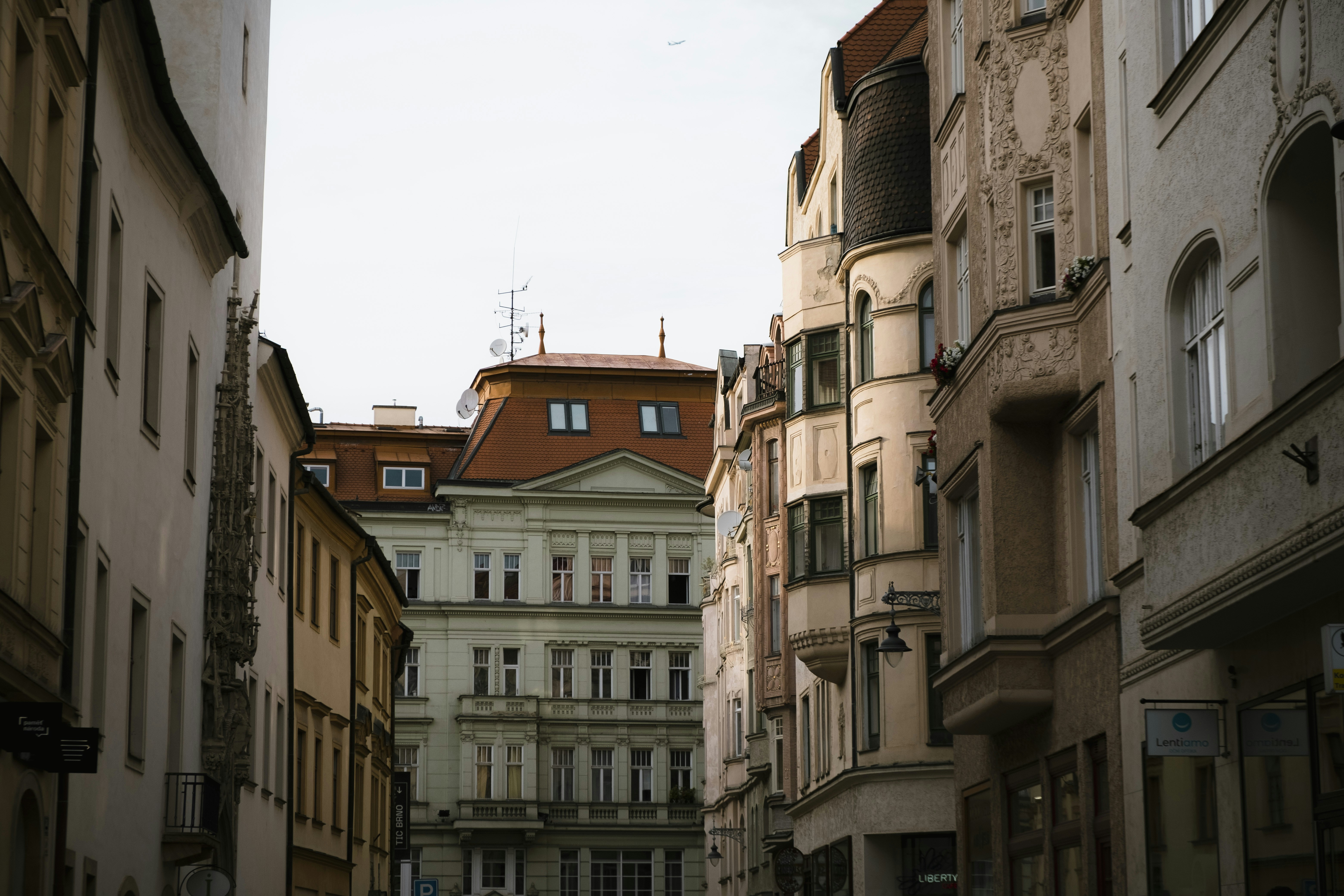 a narrow city street lined with tall buildings, Shining