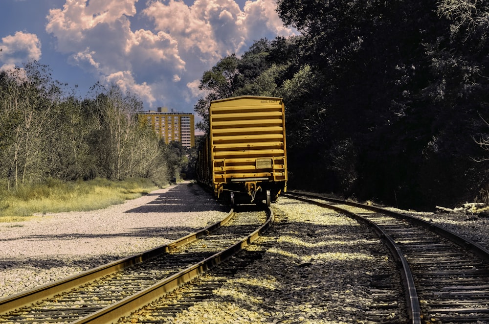 a train traveling down train tracks next to a forest