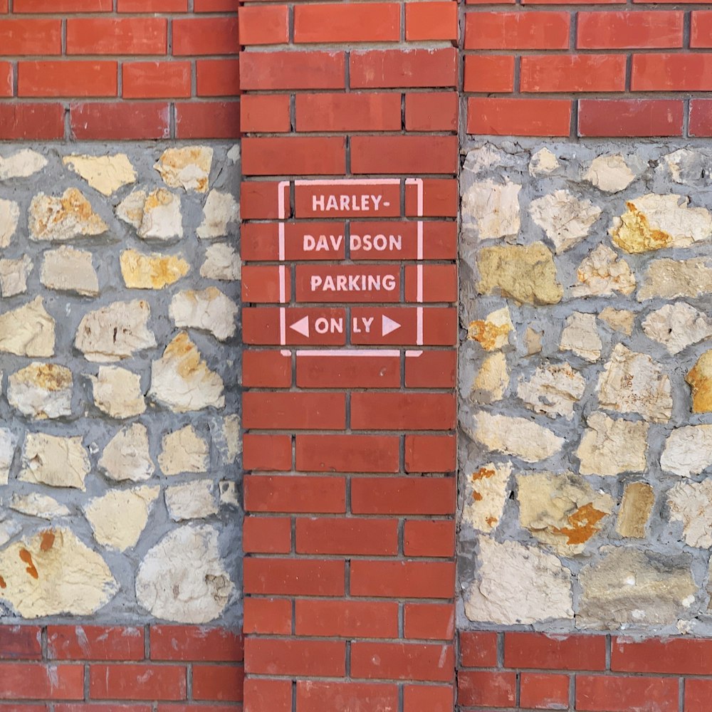 a brick wall with a street sign on it