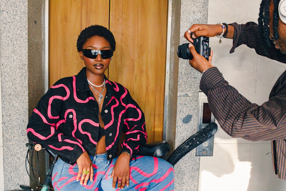 a woman sitting in a chair with a camera