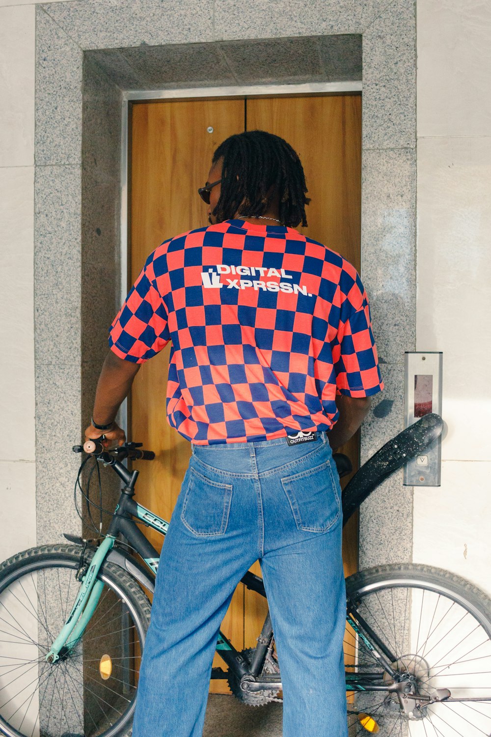 a man standing next to a bike in front of a building