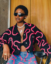 a woman sitting on a bike wearing sunglasses