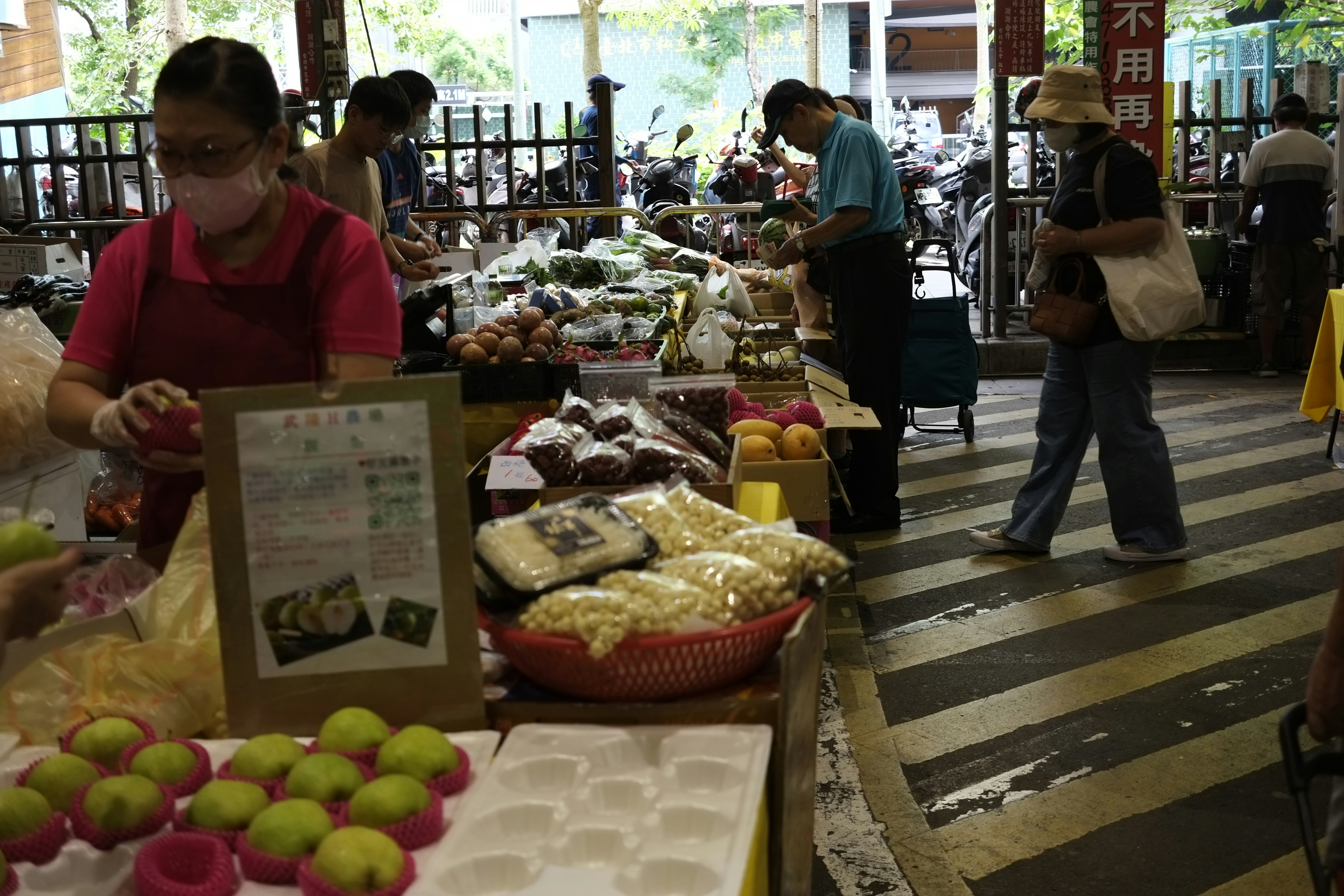 a group of people standing around a table filled with food