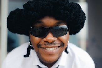 A customer smiling confidently with a bold, curly wig styled for a night out.