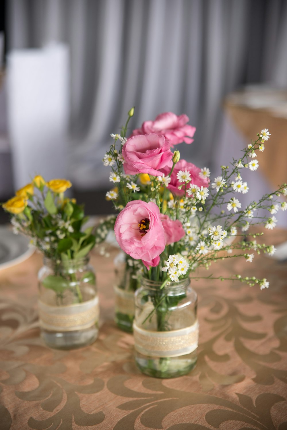 a couple of vases filled with flowers on top of a table