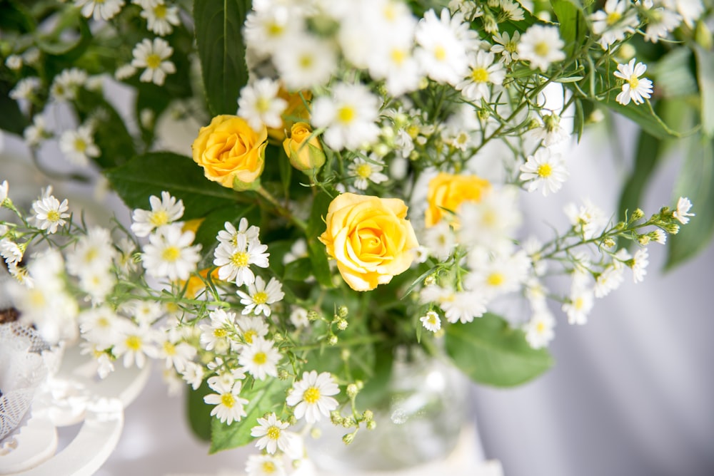 a vase filled with yellow and white flowers