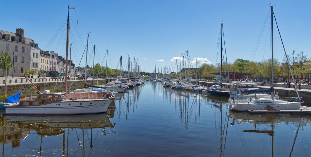 a river filled with lots of boats next to tall buildings