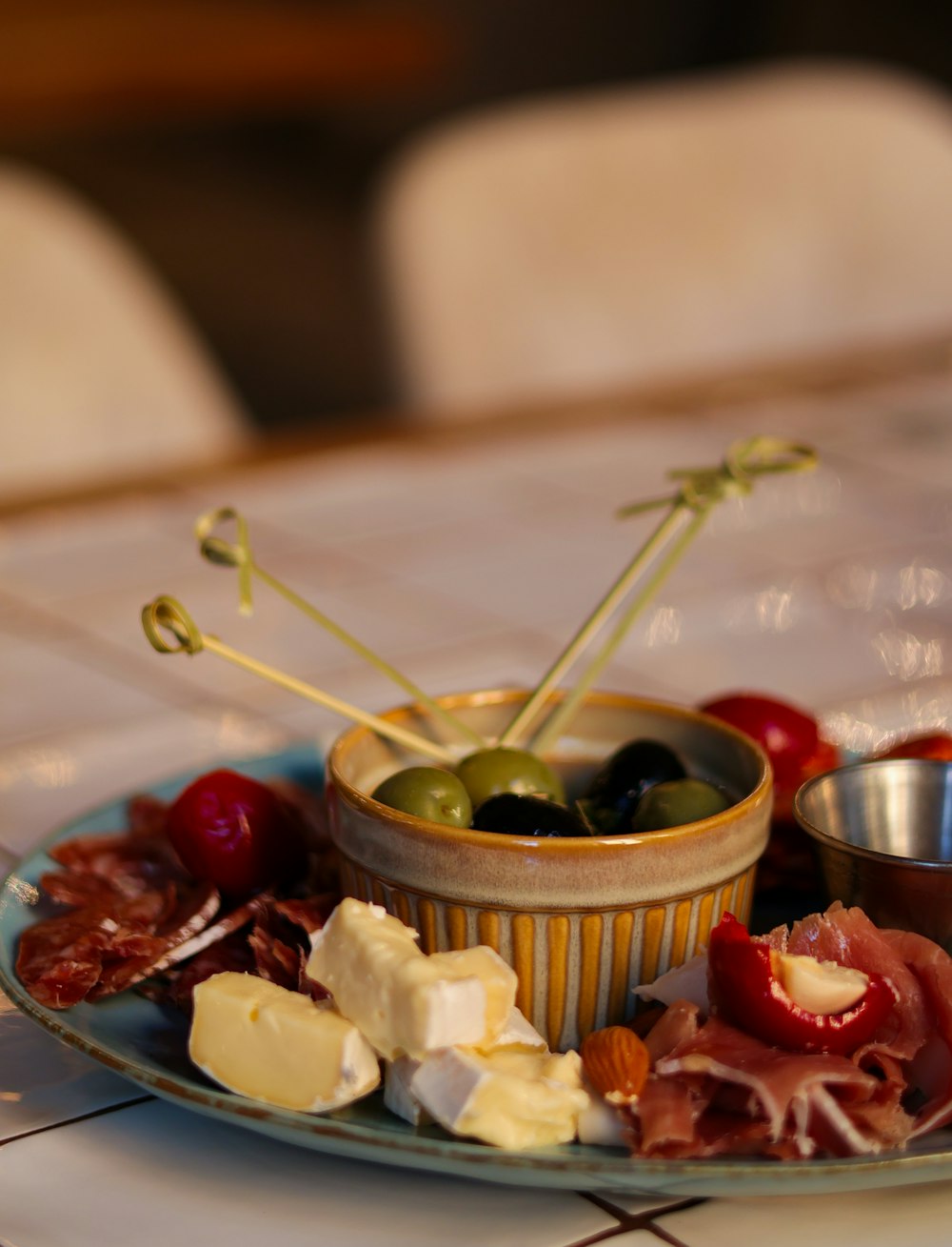 a plate of food with olives, cheese, and meat
