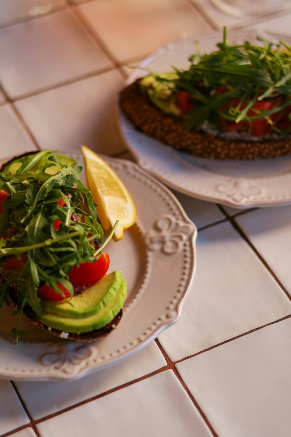 a plate with a sandwich and a slice of lemon on it