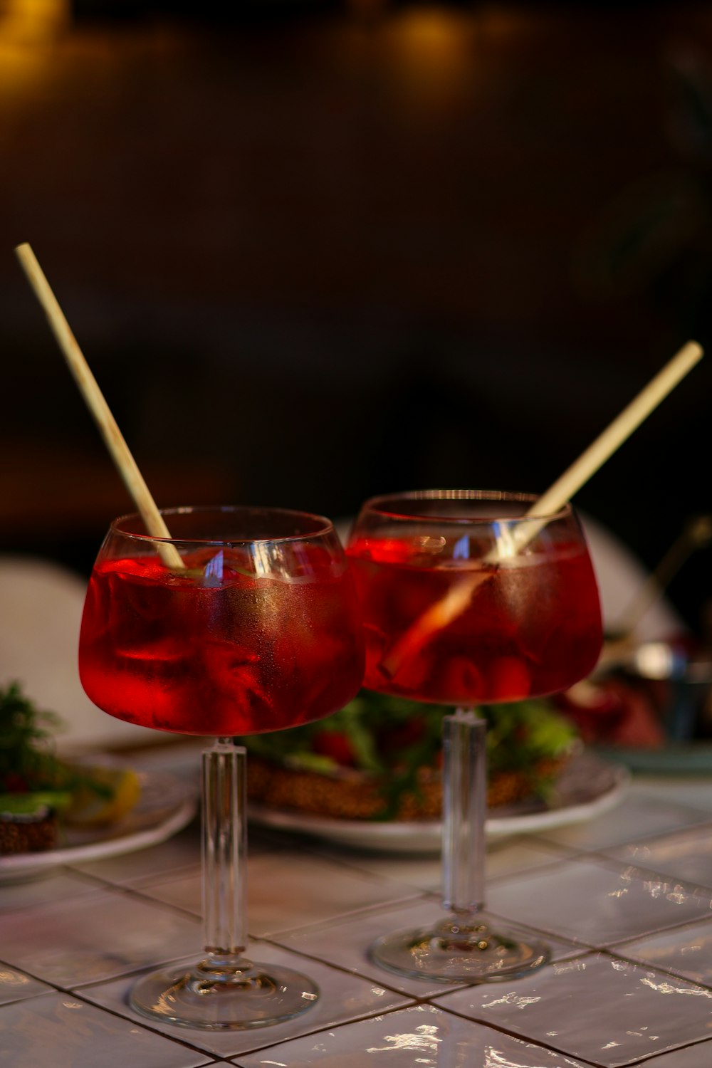 two glasses of red liquid sitting on a table