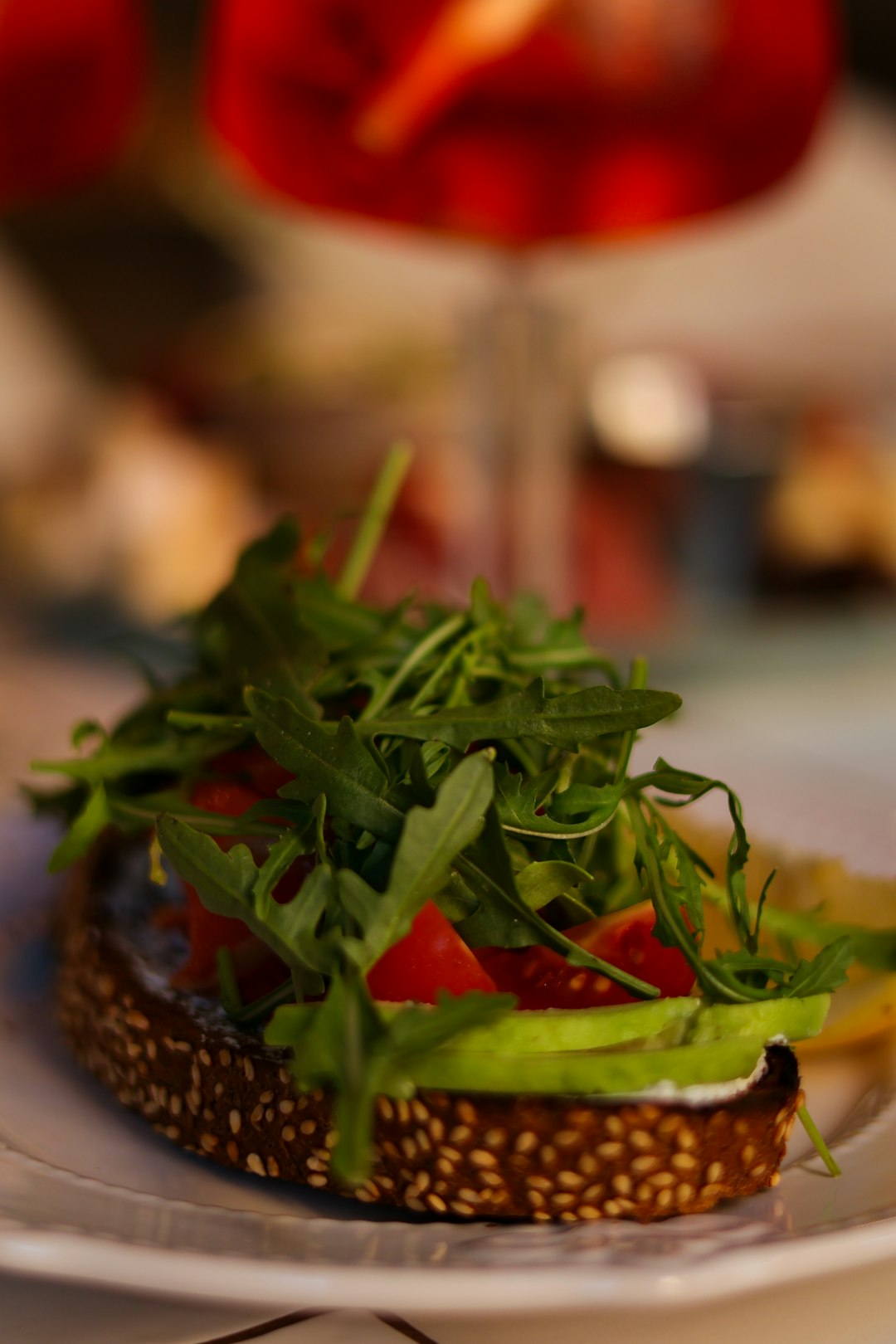 a white plate topped with a sandwich covered in veggies
