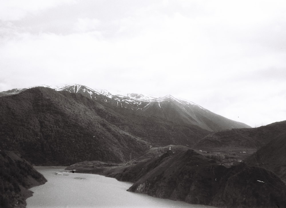 a black and white photo of a lake surrounded by mountains