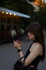 Young woman using a fitness app on her smartphone while exercising outdoors.