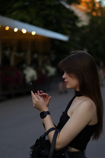 A happy young woman checking her smartwatch while jogging in a sunny park