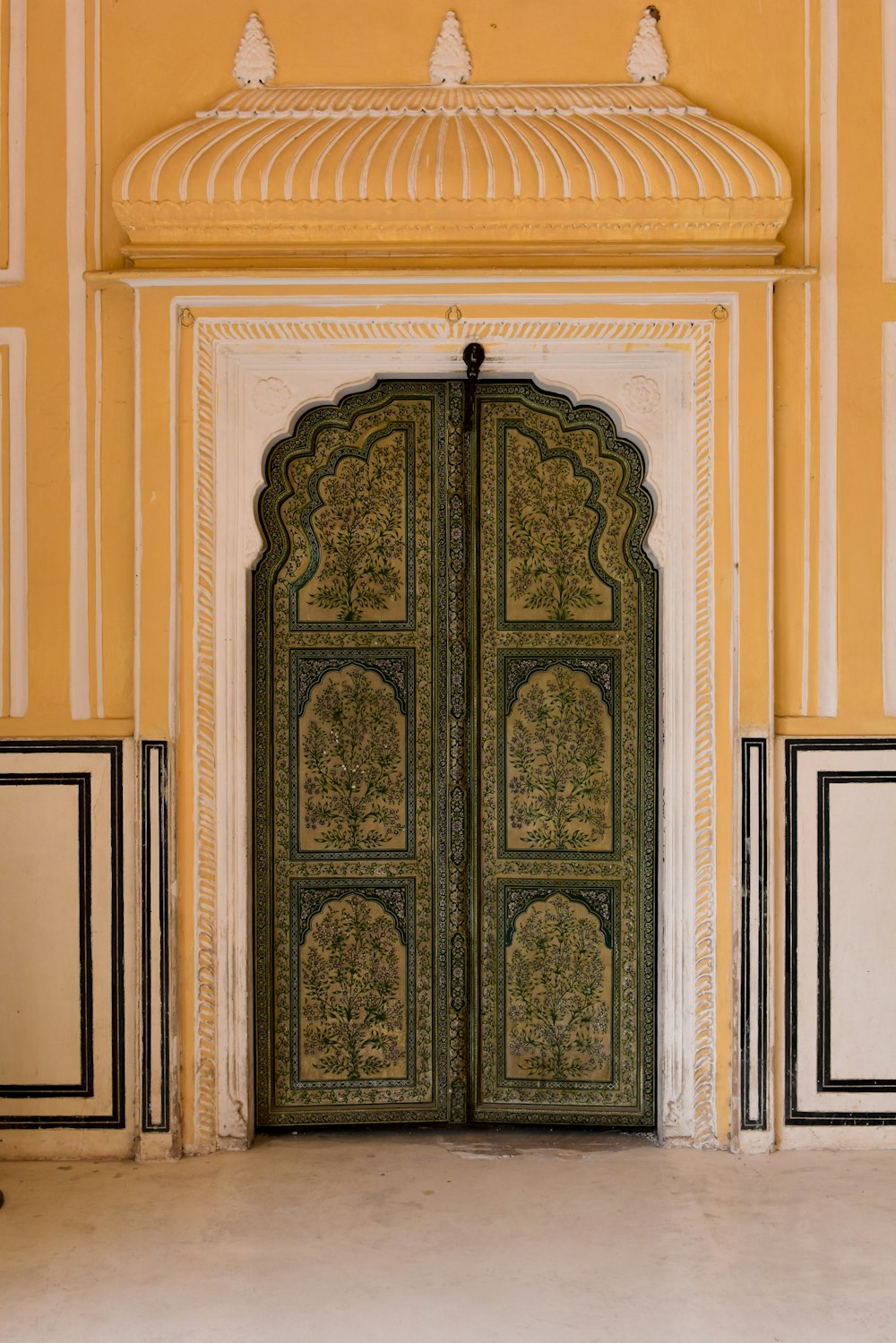 a large green door in a yellow and white building