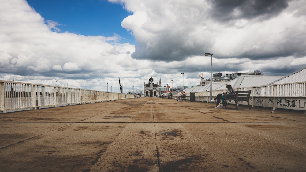 a person sitting on a bench on a bridge