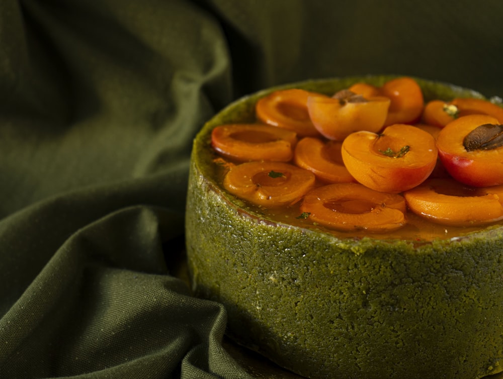 a green cake with fruit on top of it