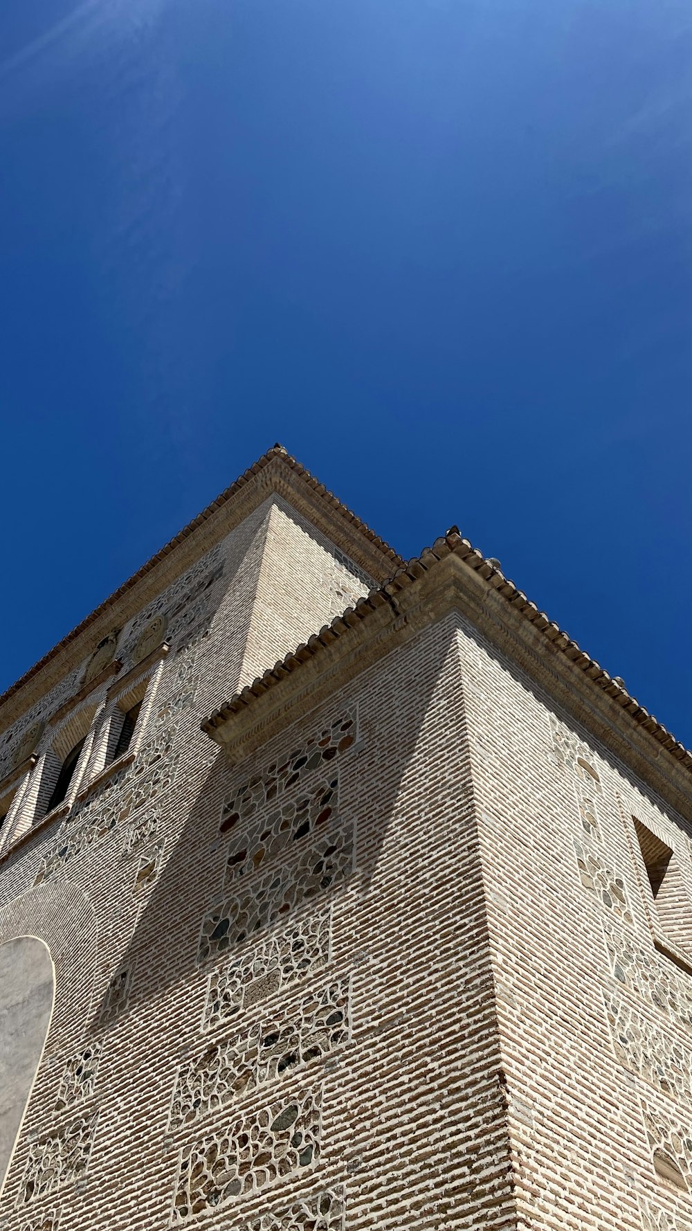 Un edificio alto de ladrillo con un reloj en su lado