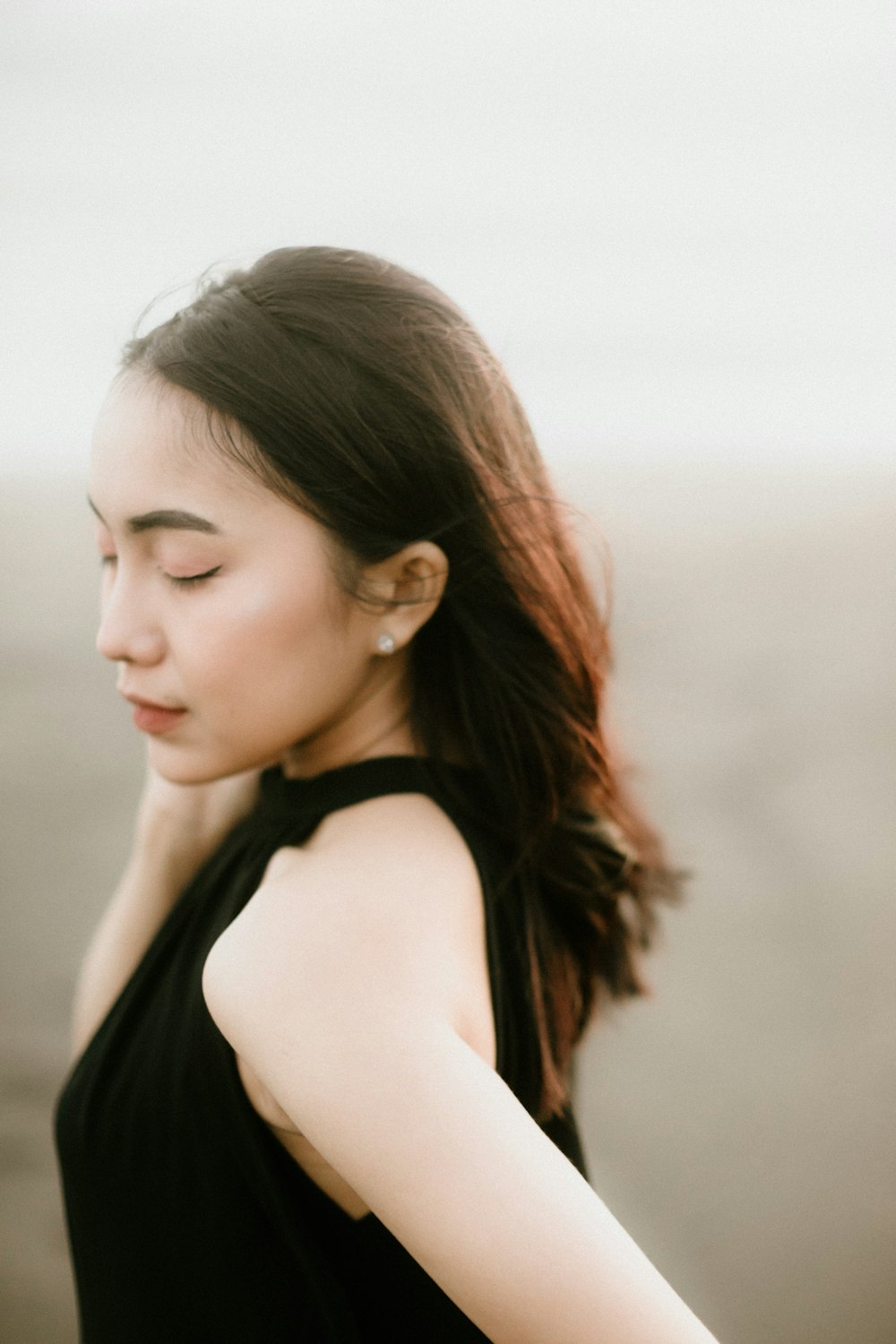 a woman in a black dress with her eyes closed