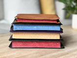 Stack of resin diaries with marbled covers arranged on a wooden table.