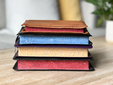 Stack of resin diaries with marbled covers arranged on a wooden table.
