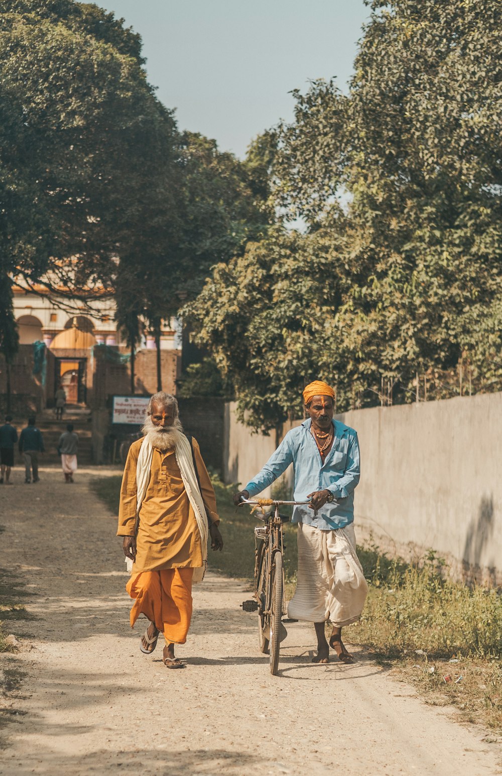 a man riding a bike down a dirt road