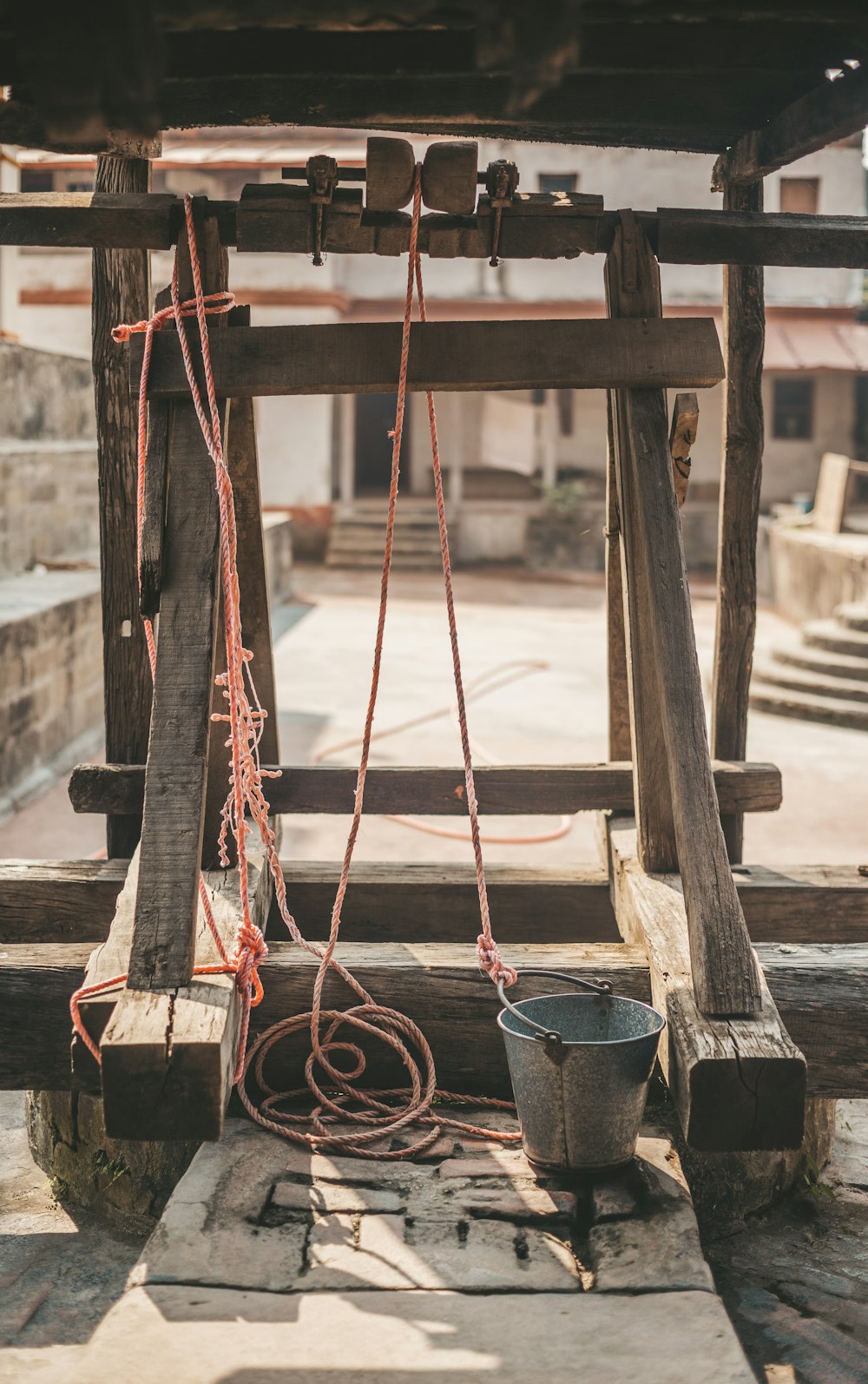 a wooden structure with ropes and buckets hanging from it