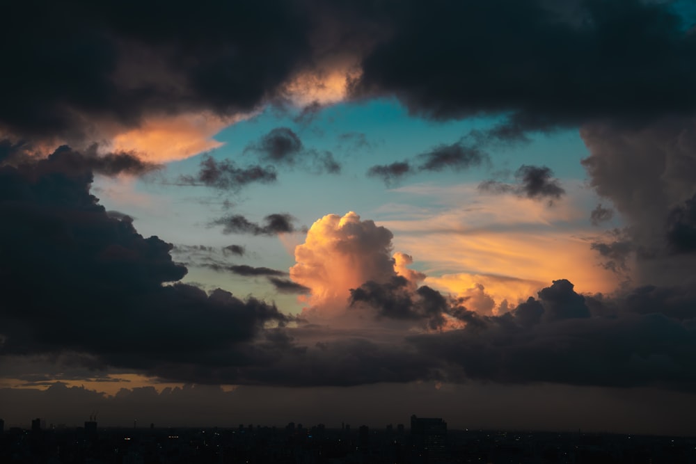 a view of a city at sunset with clouds in the sky