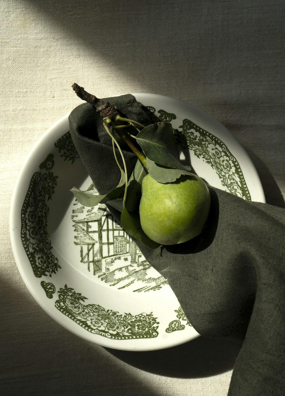 Ein grüner Apfel sitzt auf einem weißen Teller