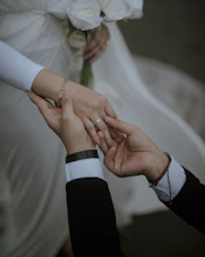 a bride and groom hold their hands together