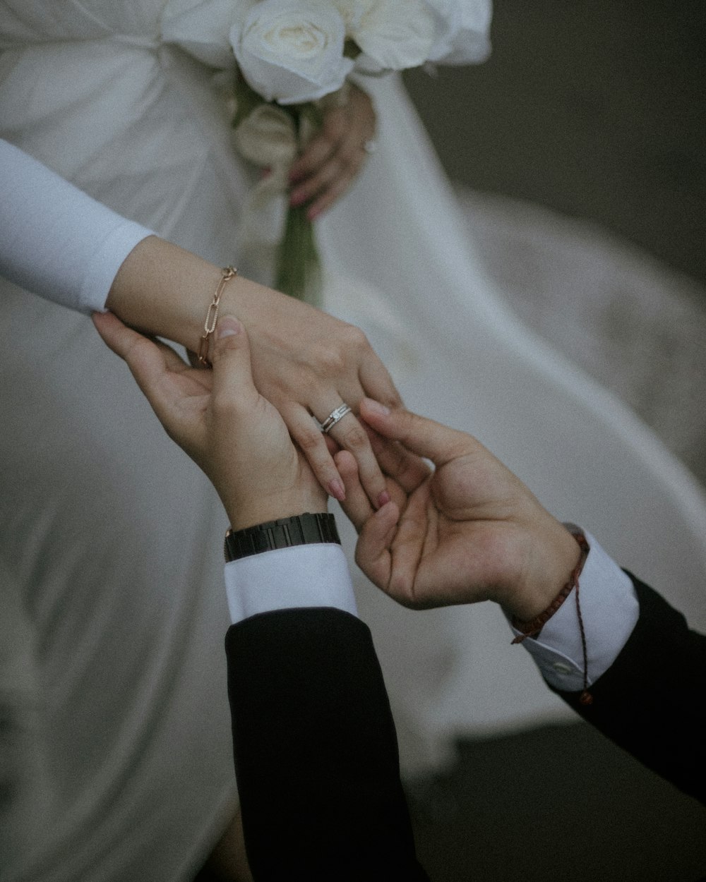 a bride and groom hold their hands together