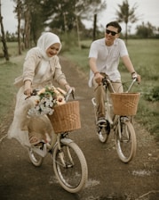 a man and a woman riding bikes down a dirt road