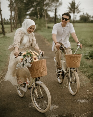 a man and a woman riding bikes down a dirt road