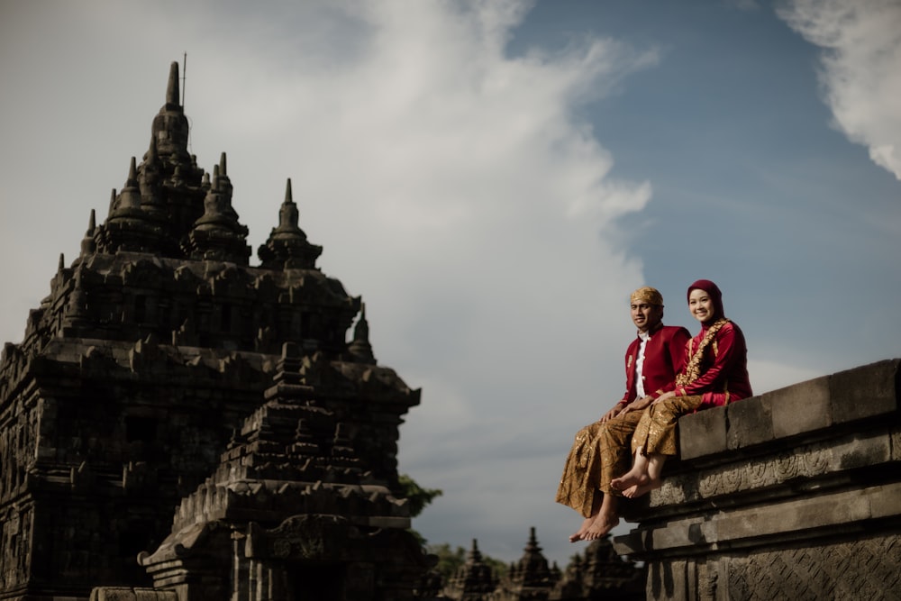 a couple of people that are sitting on a wall