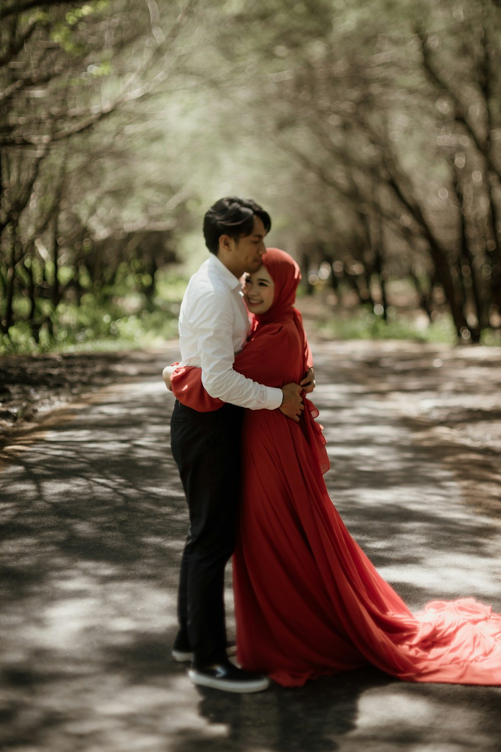 a man and a woman are hugging in the middle of the road